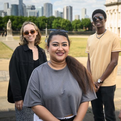 3 students smile on Greenwich campus